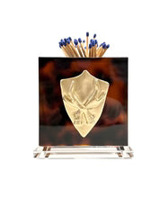 Matches in a decorative holder with a shield design on a white background